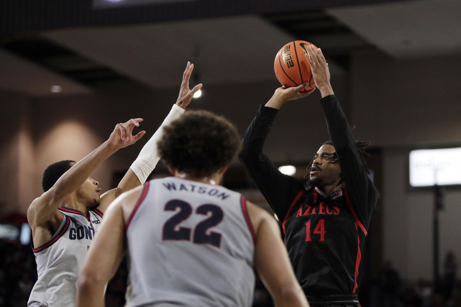 San Diego State guard Reese Waters (14) shoots while pressured by Gonzaga guard Nolan Hickman during the second half of an NCAA college basketball game, Friday, Dec. 29, 2023, in Spokane, Wash. San Diego State won 84-74.