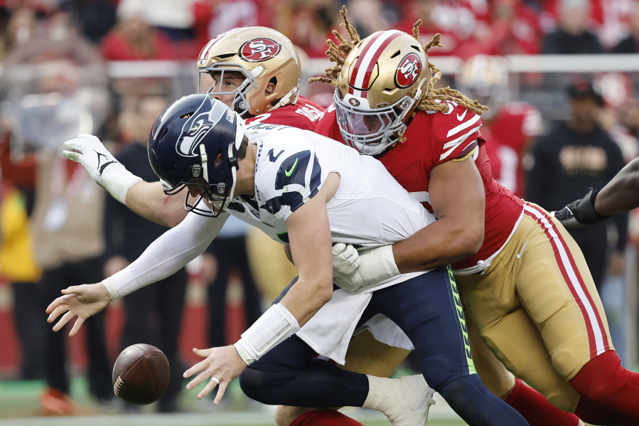 Seattle Seahawks quarterback Drew Lock, foreground, reaches for the ball in front of San Francisco 49ers defensive end Chase Young, right, and defensive end Nick Bosa on a failed two point conversion attempt during the second half of an NFL football game in Santa Clara, Calif., Sunday, Dec. 10, 2023.