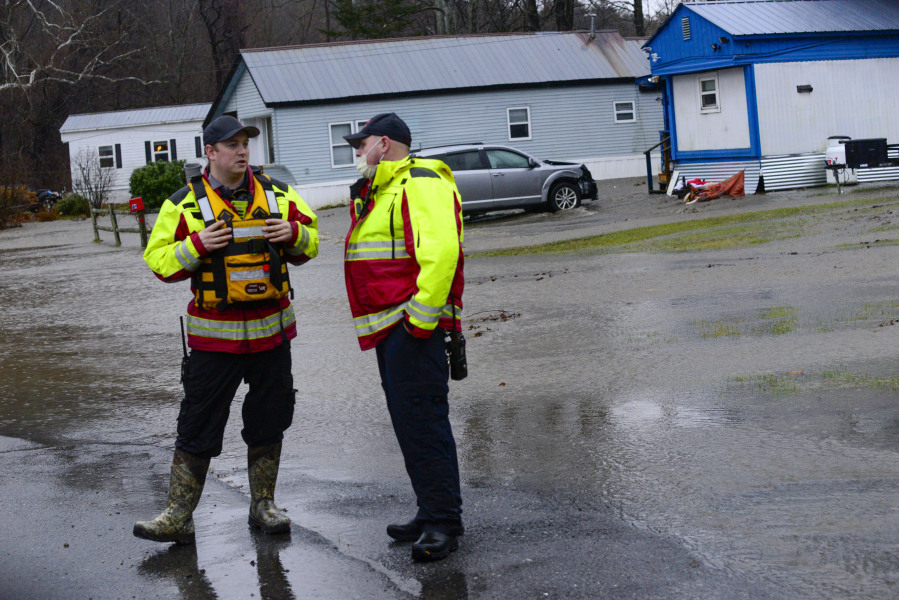 Members of the Brattleboro, Vt., Fire Department monitor the rising waters at Tri-Park Co-Op Housing as a volunteer evacuation notice was given to residents around Edgewood Drive in Brattleboro on Monday, Dec. 18, 2023.