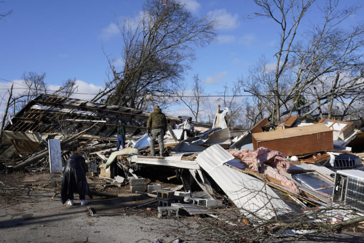 People search through a damaged mobile home along Nesbitt Road, Sunday, Dec. 10, 2023, in Nashville, Tenn. Central Tennessee residents and emergency workers are continuing the clean up from severe storms and tornadoes that hit the area.