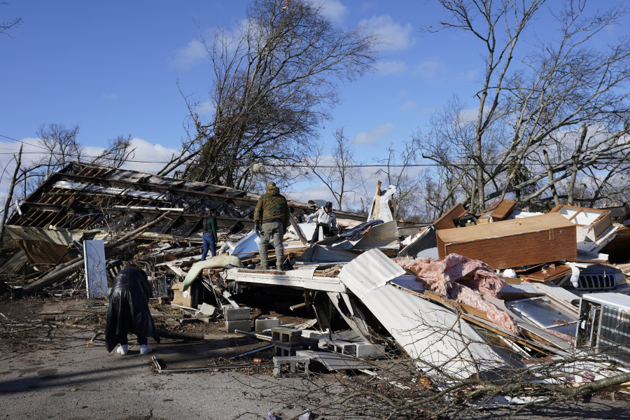 People search through a damaged mobile home along Nesbitt Road, Sunday, Dec. 10, 2023, in Nashville, Tenn. Central Tennessee residents and emergency workers are continuing the clean up from severe storms and tornadoes that hit the area.