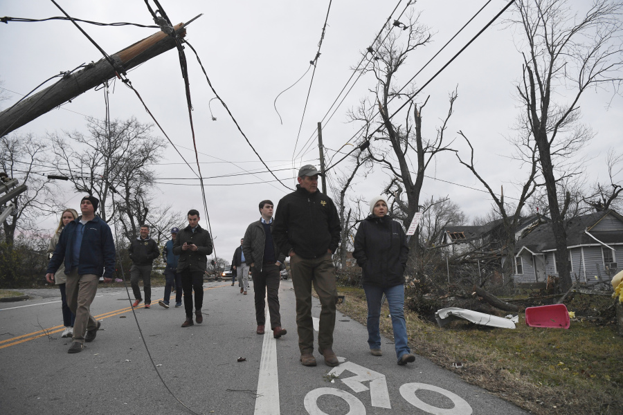 Gov. Bill Lee and first lady Maria Lee, right, walk through the streets ahead of a news conference in Madison, Tenn., Sunday, Dec. 10, 2023, following deadly tornadoes and severe weather over the weekend.