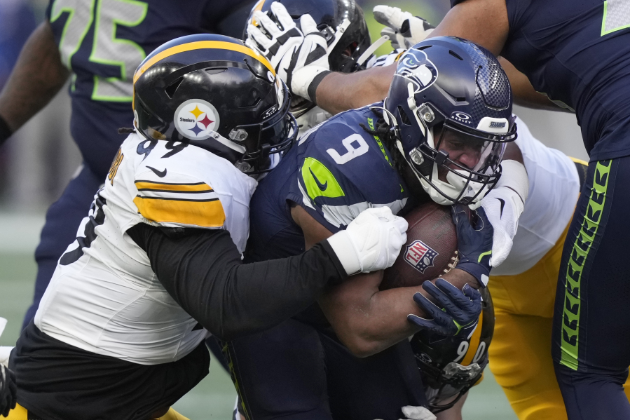 Seattle Seahawks running back Kenneth Walker III (9) is brought down by Pittsburgh Steelers defensive tackle Larry Ogunjobi (99) in the second half of an NFL football game Sunday, Dec. 31, 2023, in Seattle.