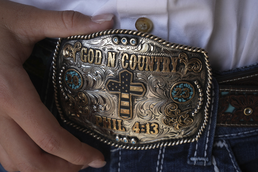 Bull rider Najiah Knight shows her belt buckle after an advertising photo shoot in Fort Worth, Texas, Wednesday, Oct. 4, 2023. Najiah, a high school junior from small-town Oregon, is on a yearslong quest to become the first woman to compete at the top level of the Professional Bull Riders tour.