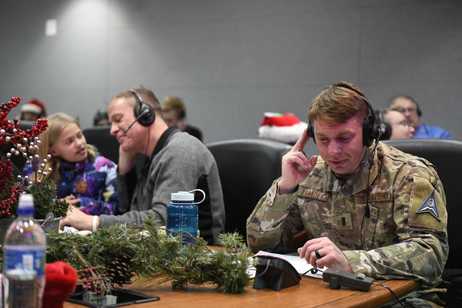 This image provided by the Department of Defense shows volunteers answering phones and emails from children around the globe during the annual NORAD Tracks Santa event on Peterson Air Force Base in Colorado Springs, Colo., Dec. 24, 2022.