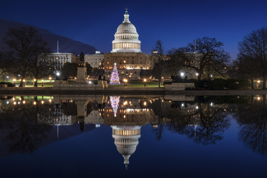 The U.S. Capitol building and the Capitol Christmas Tree are mirrored in the still waters of a reflecting pool early Christmas morning in Washington. (J.