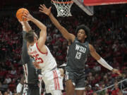 Washington State forward Isaac Jones (13) defends against Utah guard Rollie Worster (25) during the second half of an NCAA college basketball game Friday, Dec. 29, 2023, in Salt Lake City.
