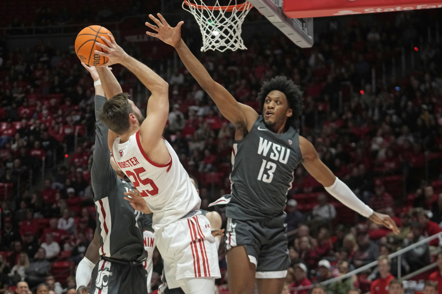 Washington State forward Isaac Jones (13) defends against Utah guard Rollie Worster (25) during the second half of an NCAA college basketball game Friday, Dec. 29, 2023, in Salt Lake City.