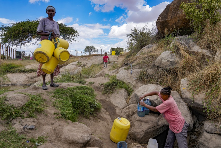 Joyce Ngui, left, fetches water in Athi River, Machakos county, Kenya, Oct. 17.