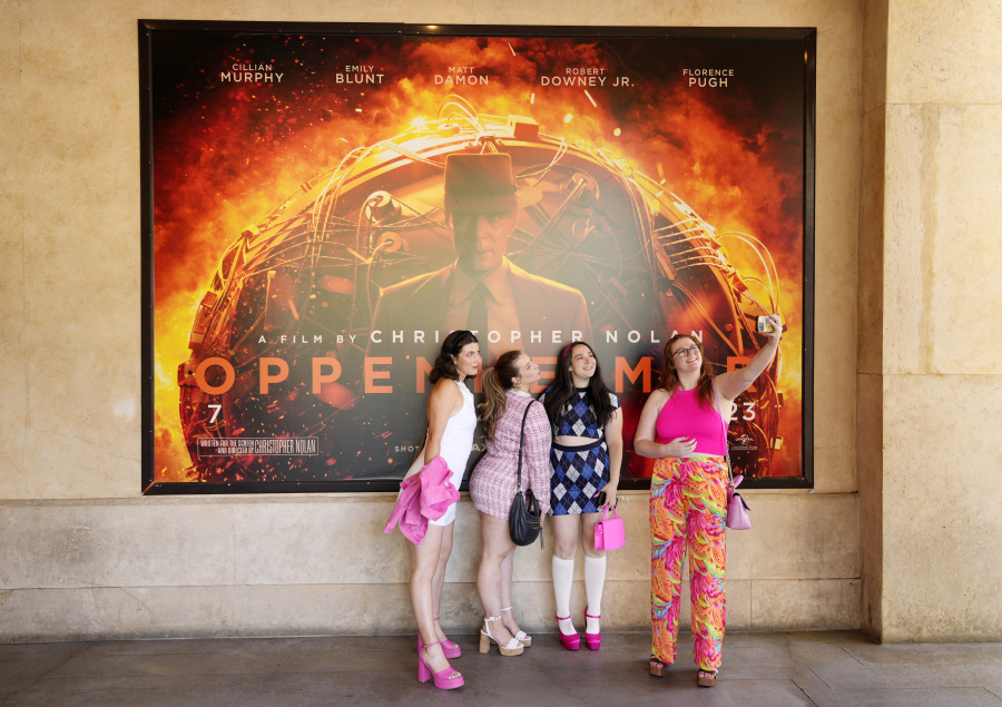 From left, Gabrielle Roitman, Kayla Seffing, Maddy Hiller and Casey Myer take a selfie in front of an &ldquo;Oppenheimer&rdquo; movie poster before they attended an advance screening of &ldquo;Barbie,&rdquo; Thursday, July 20, 2023, at AMC The Grove 14 theaters in Los Angeles.