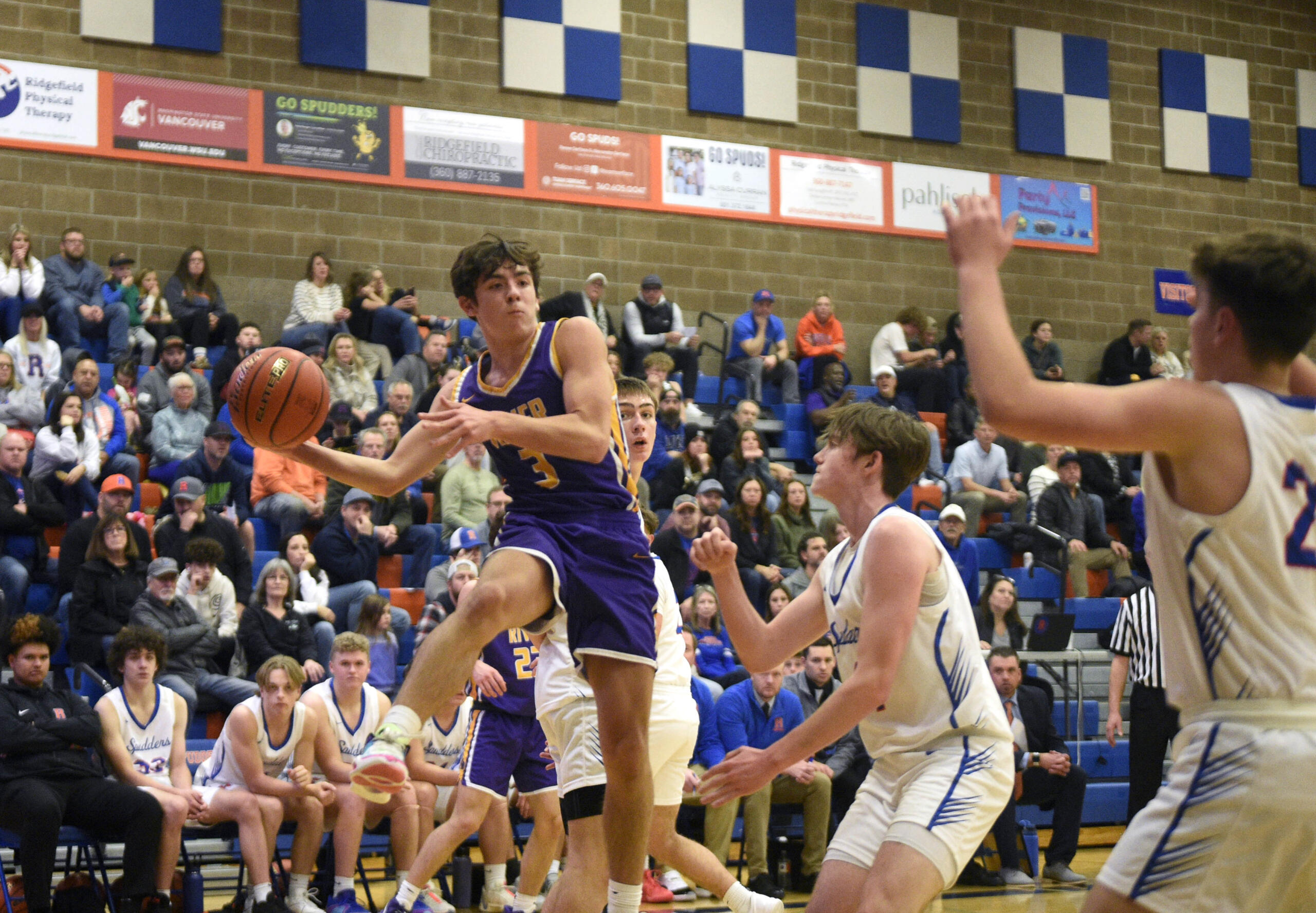 Columbia River’s Ari Richardson looks to throw a pass from the baseline against Ridgefield during a 2A GSHL boys basketball game on Thursday, Jan. 4, 2024, at Ridgefield High School.