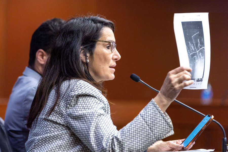 Parent Beth Gann holds a photo of swastika vandalism while speaking on behalf of HB 144 during a Senate Children and Families Committee meeting at the Paul D. Coverdell Legislative Office Building in Atlanta on March 23, 2023. HB 144 would include antisemitism as part of the state&rsquo;s hate crimes law.