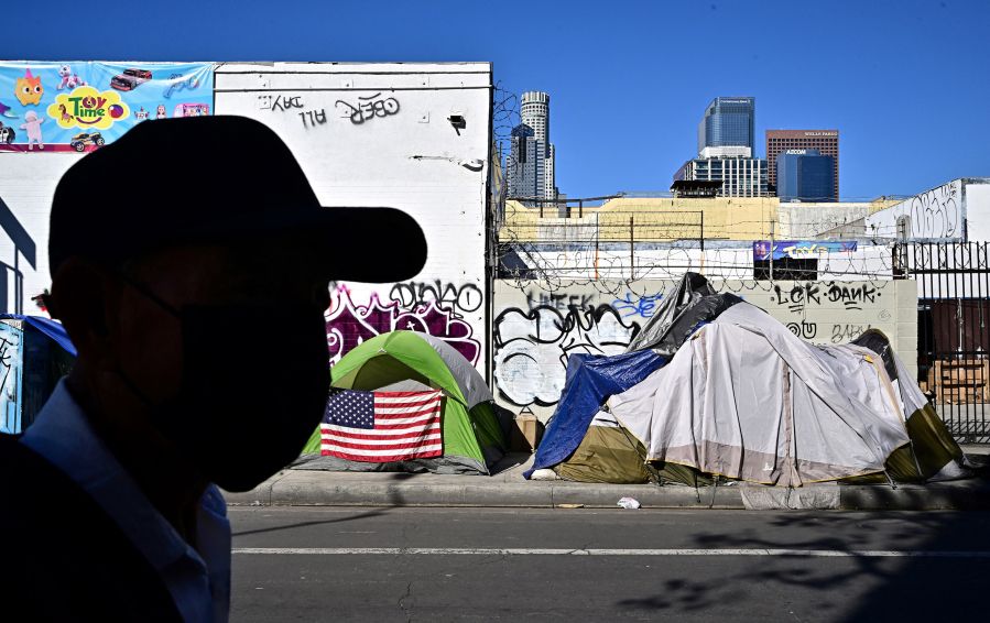 A man walks past tents housing the homeless on Nov. 22 in Los Angeles. (Frederic J.