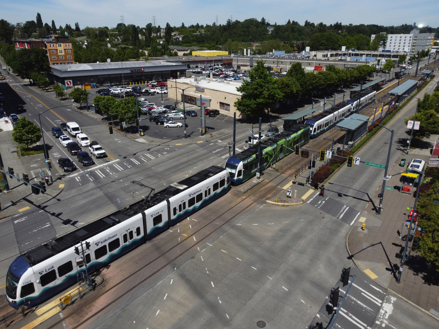 A southbound light-rail train travels through two crosswalks at the south end of the Othello station on June 7, 2022, in Seattle. The train runs along Martin Luther King Jr. Way South.