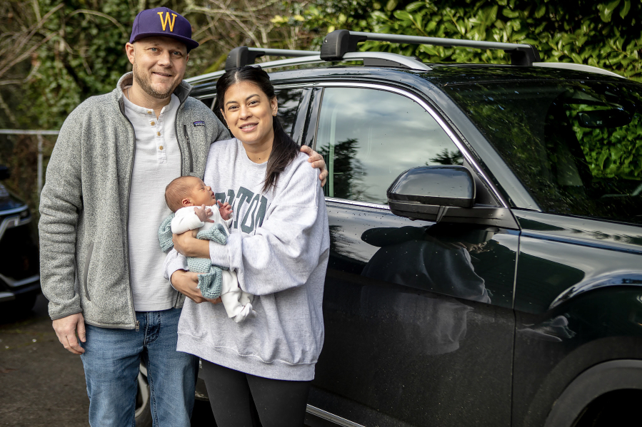 Jake Hitchner, left, and Caitlin Hitchner pose Jan. 7 with their son Boston at their home in Edmond. The boy was born Dec. 30 in the couple&rsquo;s vehicle on Interstate 5.