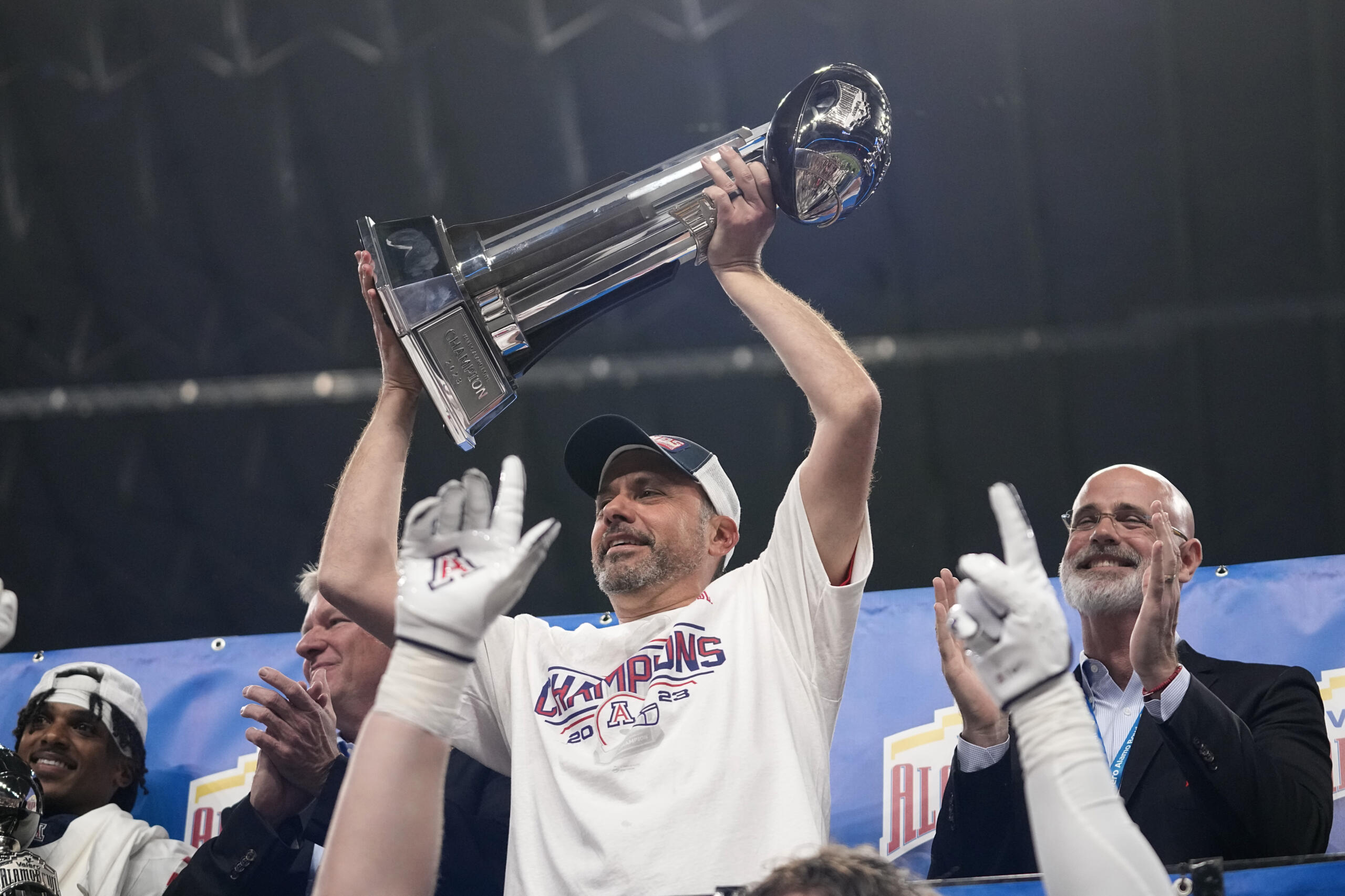 Arizona head coach Jedd Fisch lifts the team's trophy after defeating Oklahoma in the Alamo Bowl NCAA college football game in San Antonio, Thursday, Dec. 28, 2023.