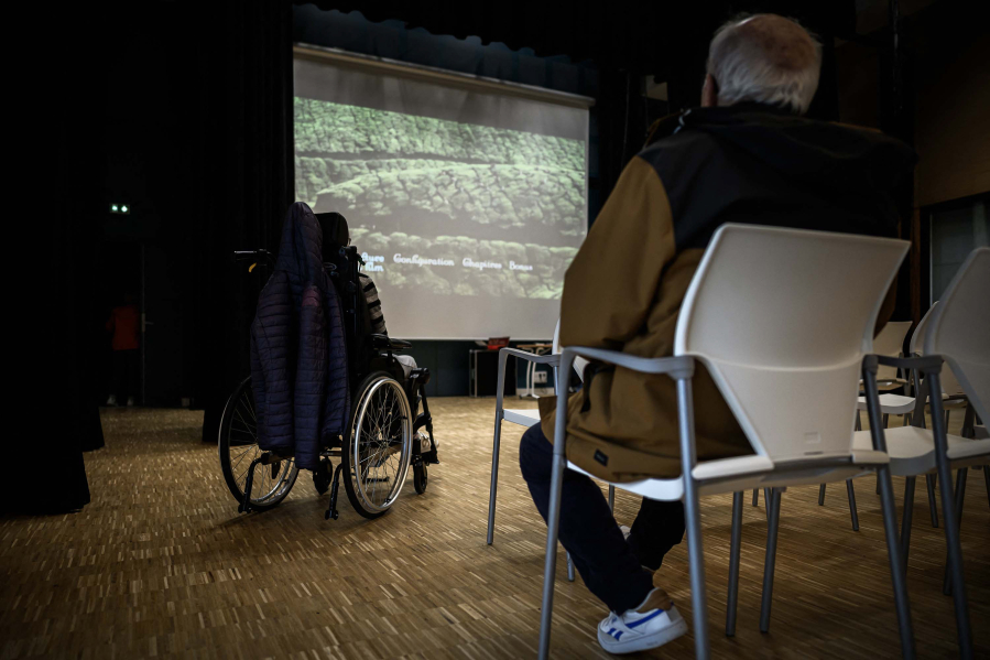 A patient with Alzheimer watches a movie at the auditorium of the village Landais Alzheimer site for patients with Alzheimer in Dax, France, on Nov. 30, 2023.