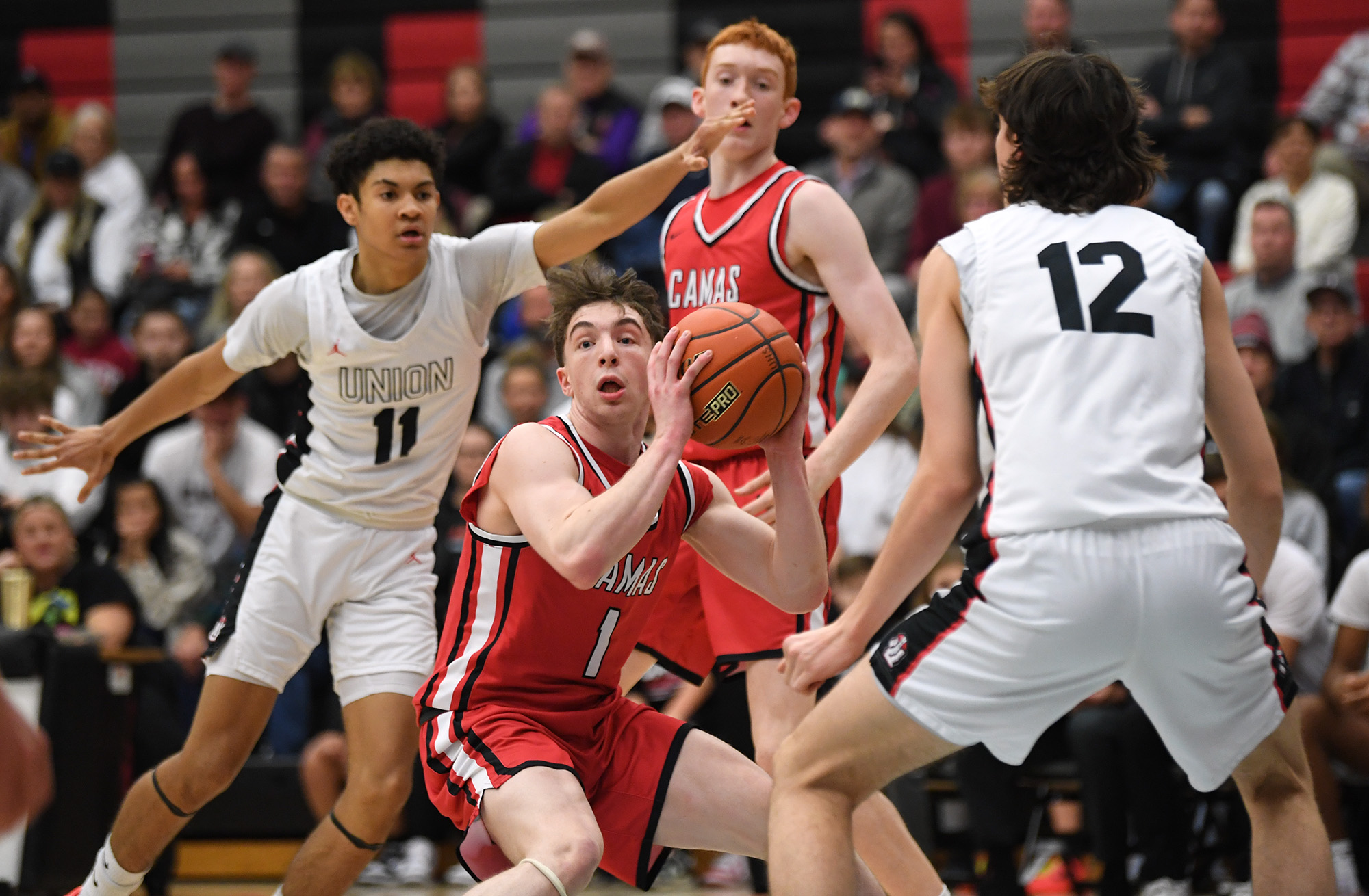 Camas junior Beckett Currie, center, looks to pass Tuesday, Jan. 2, 2024, during the Papermakers’ 71-33 win against Union at Union High School.