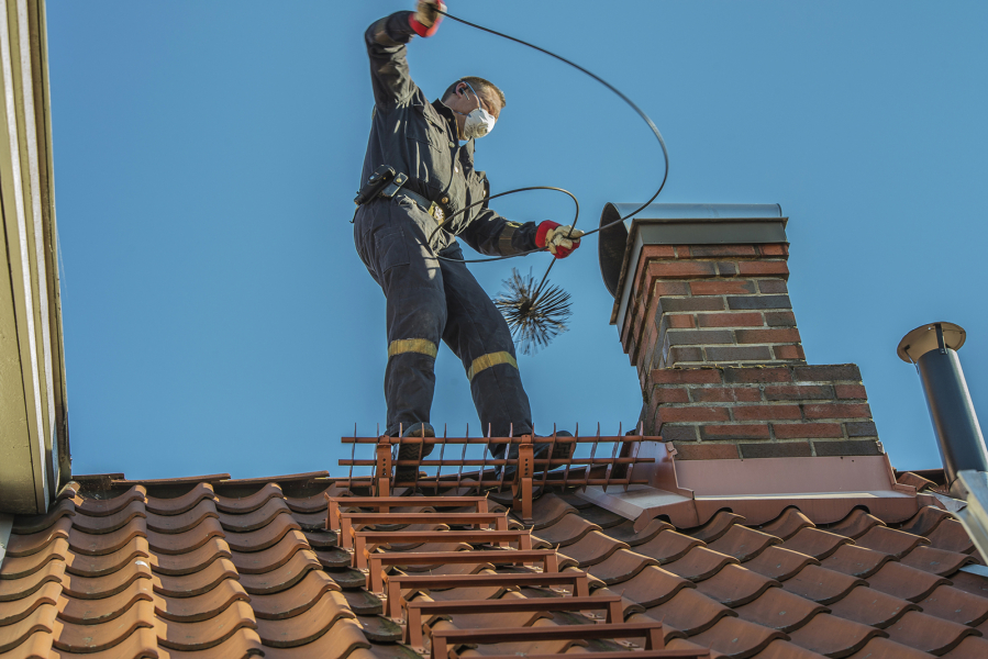 A chimney sweep will use various tools to clear out debris.