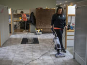 Shannon Eagen-Anderson, background left, and Jahnea Lecouris of Couve Cleaning tackle a cleaning job Jan. 12 at Vancouver Bolt &amp; Supply.