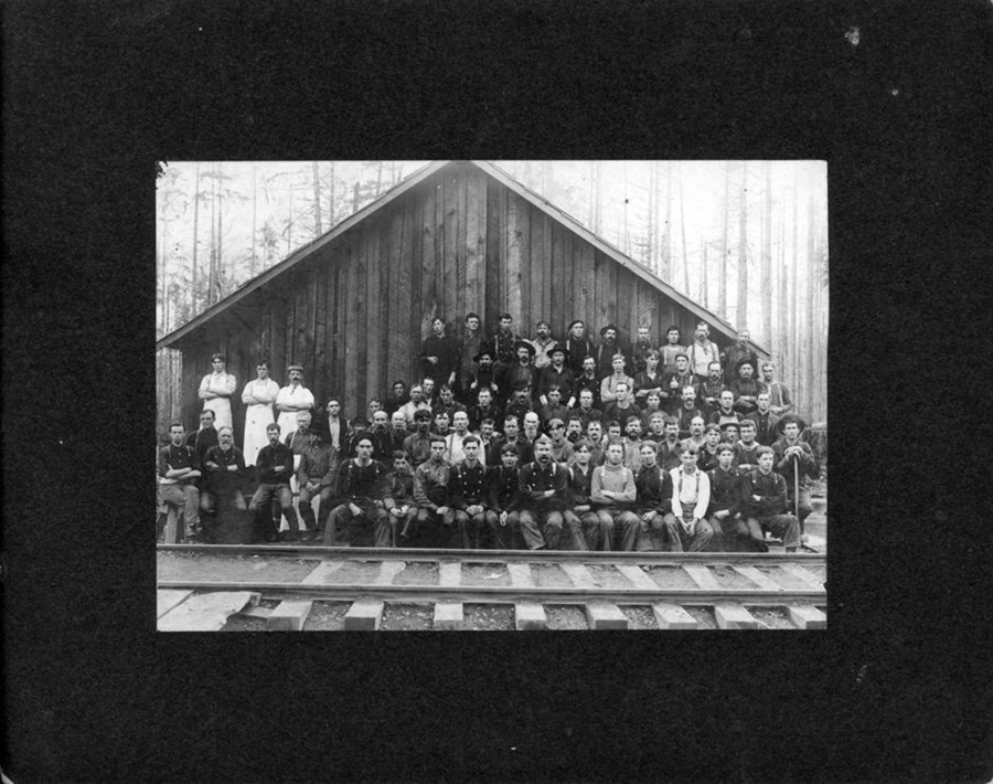 Loggers pose at a Weyerhaeuser Timber Company lumber camp in Yacolt. The Yacolt Burn of 1902 created as many as 700 jobs salvaging the burnt timber. Workers loaded charred logs on railroad flatcars and sent them to Vancouver daily.