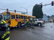 Firefighters from the Vancouver Fire Department respond to a collision between an SUV and school bus Wednesday morning in the Image neighborhood. Four people, including three students, were treated for minor injuries.