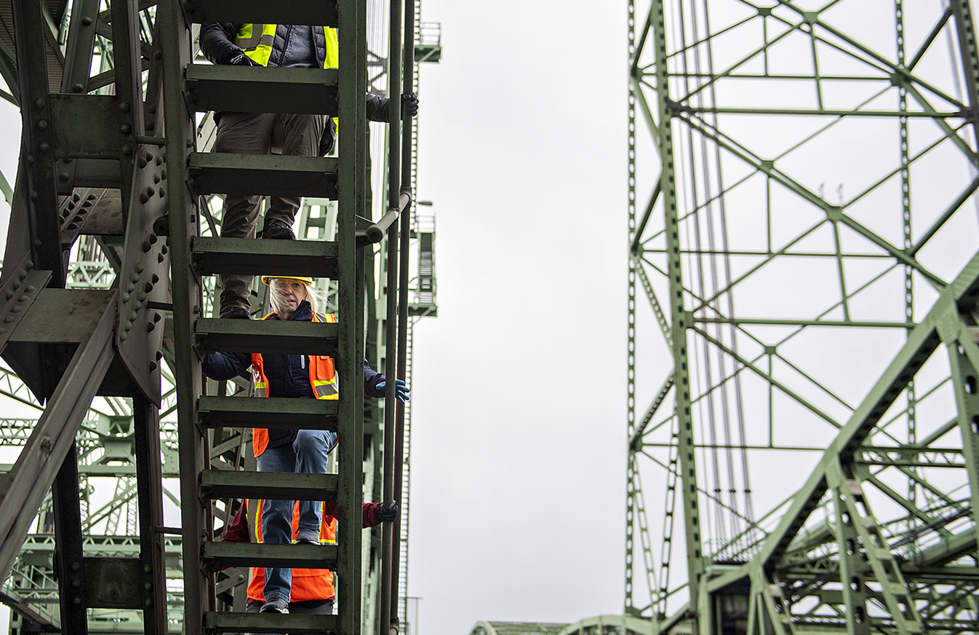 Sen. Patty Murray, left, is seen through the steps of a ladder as she climbs to the east machine room during a tour of the Interstate Bridge on Wednesday afternoon, Jan. 3, 2024.