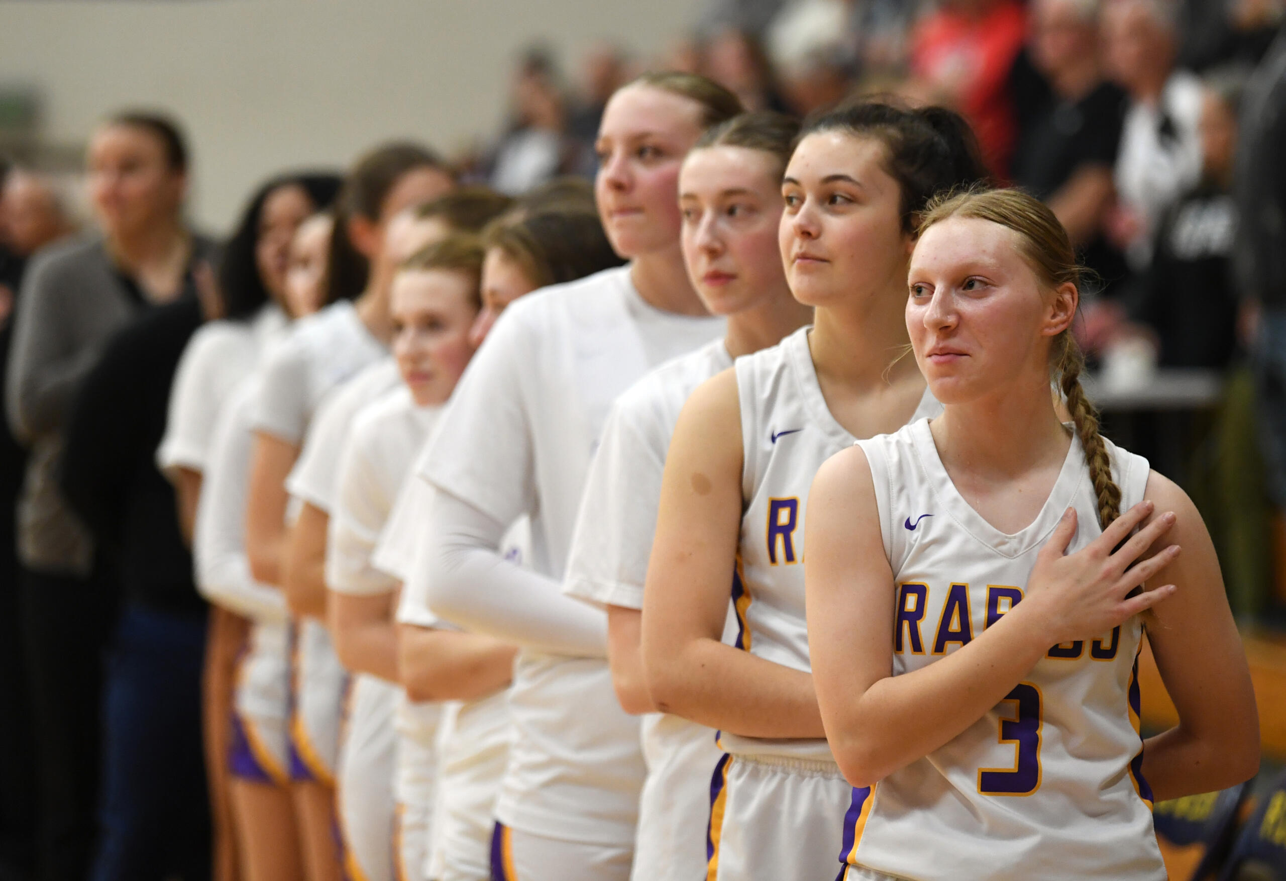 Columbia River junior Marley Myers, right, and the rest of the team stand during the national anthem Friday, Jan. 5, 2024, during the Rapids’ 43-33 win against Ridgefield at Columbia River High School.