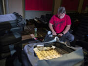 Amanda Cowan/The Columbian 
 Volunteer Steve Bader takes part in a big reupholstery project Friday at the Kiggins Theater. The Kiggins has shut down for two weeks and rounded up local volunteers to refurbish more than 100 worn and damaged seats.