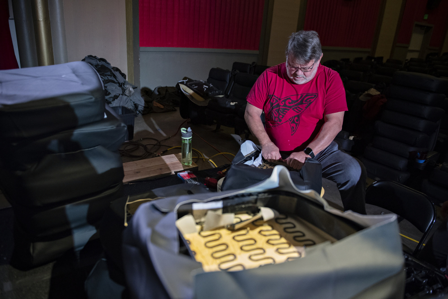 Amanda Cowan/The Columbian 
 Volunteer Steve Bader takes part in a big reupholstery project Friday at the Kiggins Theater. The Kiggins has shut down for two weeks and rounded up local volunteers to refurbish more than 100 worn and damaged seats.