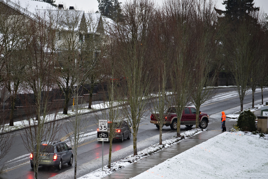 Drivers in Salmon Creek navigate soggy streets while passing a light blanket of snow Wednesday morning. Southwest Washington saw varied snowfall from barely more than a trace in lowland Vancouver to accumulations in areas at higher elevation in Cowlitz County.