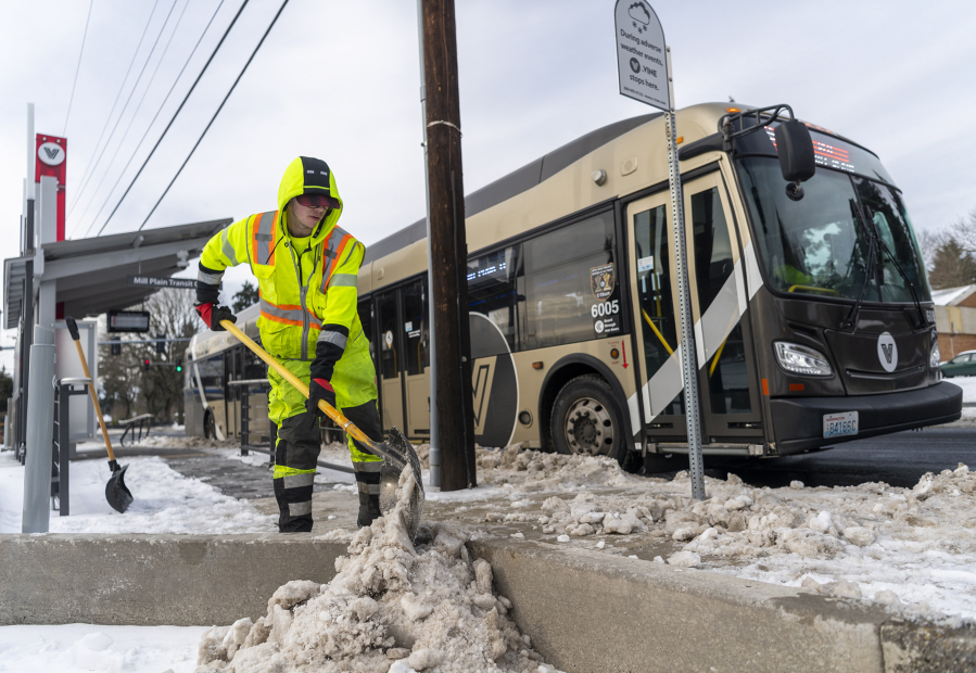 C-Tran facility service worker Sterling Hinkle shovels snow away from a Vine bus stop on Mill Plain on Tuesday in Vancouver. As if snow and days of subfreezing temperatures weren't enough, the National Weather Service in Portland issued an ice storm warning through 4 a.m. Wednesday.
