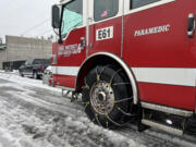 A Clark County Fire District 6 truck responds to a call Thursday afternoon in Hazel Dell. Fire trucks were equipped with chains on tires to navigate icy neighborhood streets after freezing rain turned lingering snow slick.