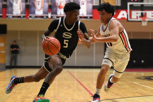 Skyview senior Demaree Collins, left, dribbles against Camas junior Nyima Namru on Tuesday, Jan. 23, 2024, during the Storm’s 69-66 loss to Camas at Camas High School.