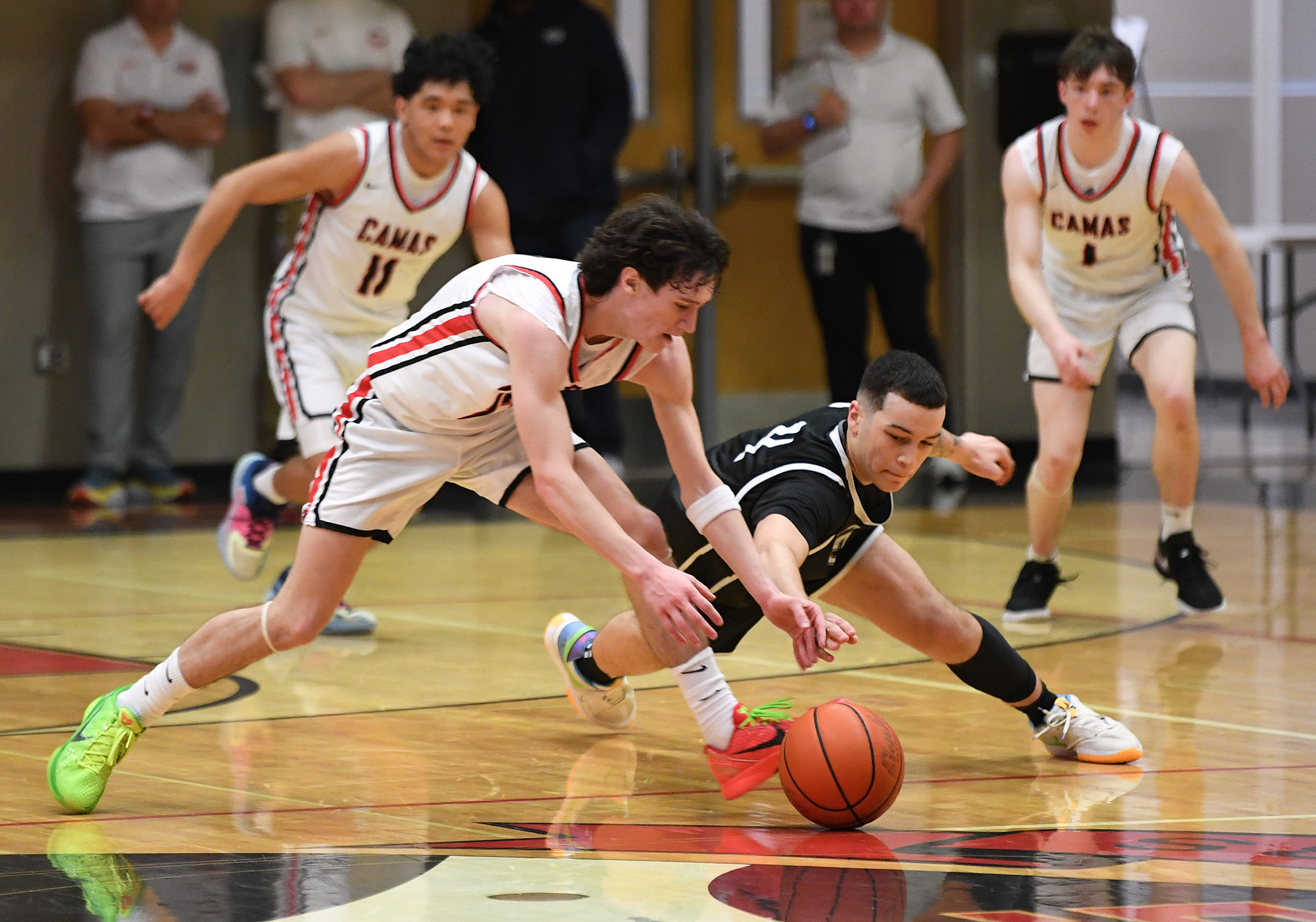 Camas junior Jace VanVoorhis, left, and Skyview sophomore Malakai Weimer dive for a ball Tuesday, Jan. 23, 2024, during the Papermakers’ 69-66 win against Skyview at Camas High School.