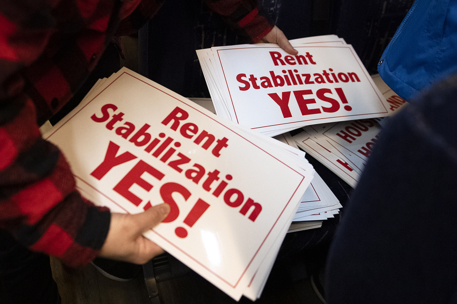 Participants gather signs on their way to advocate for rent stabilization in front of the state Legislature on Tuesday morning. The trip was part of Housing and Homelessness Advocacy Day.