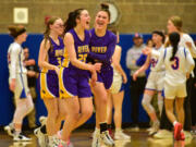 Columbia River senior Emma Iniguez (20) celebrates with teammates junior Marley Myers (3) and senior Paige Johnson, right, after a Ridgefield timeout Wednesday, Jan. 31, 2024, during the Rapids’ 54-47 win against Ridgefield at Ridgefield High School.