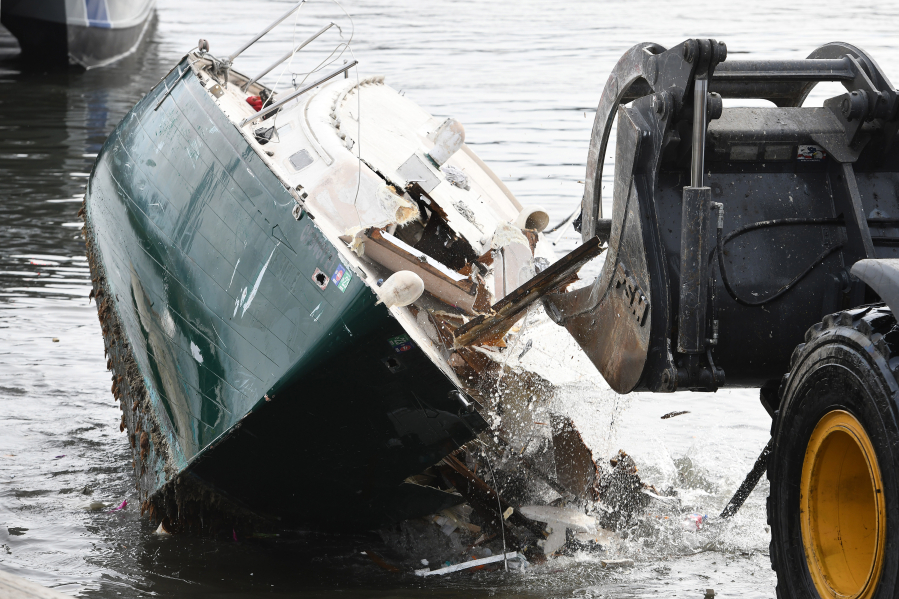 A front-end loader breaks apart a derelict boat from the waters of Oakland Alameda Estuary in Oakland, Calif., on Dec. 21. The Oakland Police Marine unit removed the boats from the shore and towed them to the parking lot of the Jack London Aquatic Center where they were destroyed and loaded into large dump trucks.