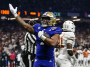 Washington running back Dillon Johnson (7) celebrates his touchdown against Texas during the first half of the Sugar Bowl CFP NCAA semifinal college football game, Monday, Jan. 1, 2024, in New Orleans.