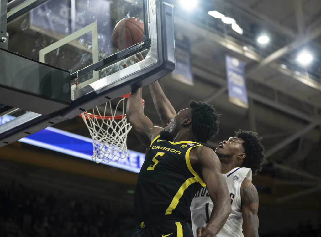 Oregon guard Jermaine Couisnard, left, shoots against Washington forward Keion Brooks Jr., right, during the second half of an NCAA college basketball game, Thursday, Jan. 4, 2024, in Seattle.