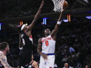 New York Knicks' OG Anunoby (8) drives past Portland Trail Blazers' Jerami Grant (9) during the second half of an NBA basketball game Tuesday, Jan. 9, 2024, in New York. The Knicks won 112-84.
