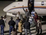 New Alabama football head coach Kalen DeBoer, center, waves to cheering fans as he steps off the plane at Tuscaloosa National Airport two days after former coach Nick Saban announced his retirement Friday, Jan. 12, 2024, in Tuscaloosa, Ala.