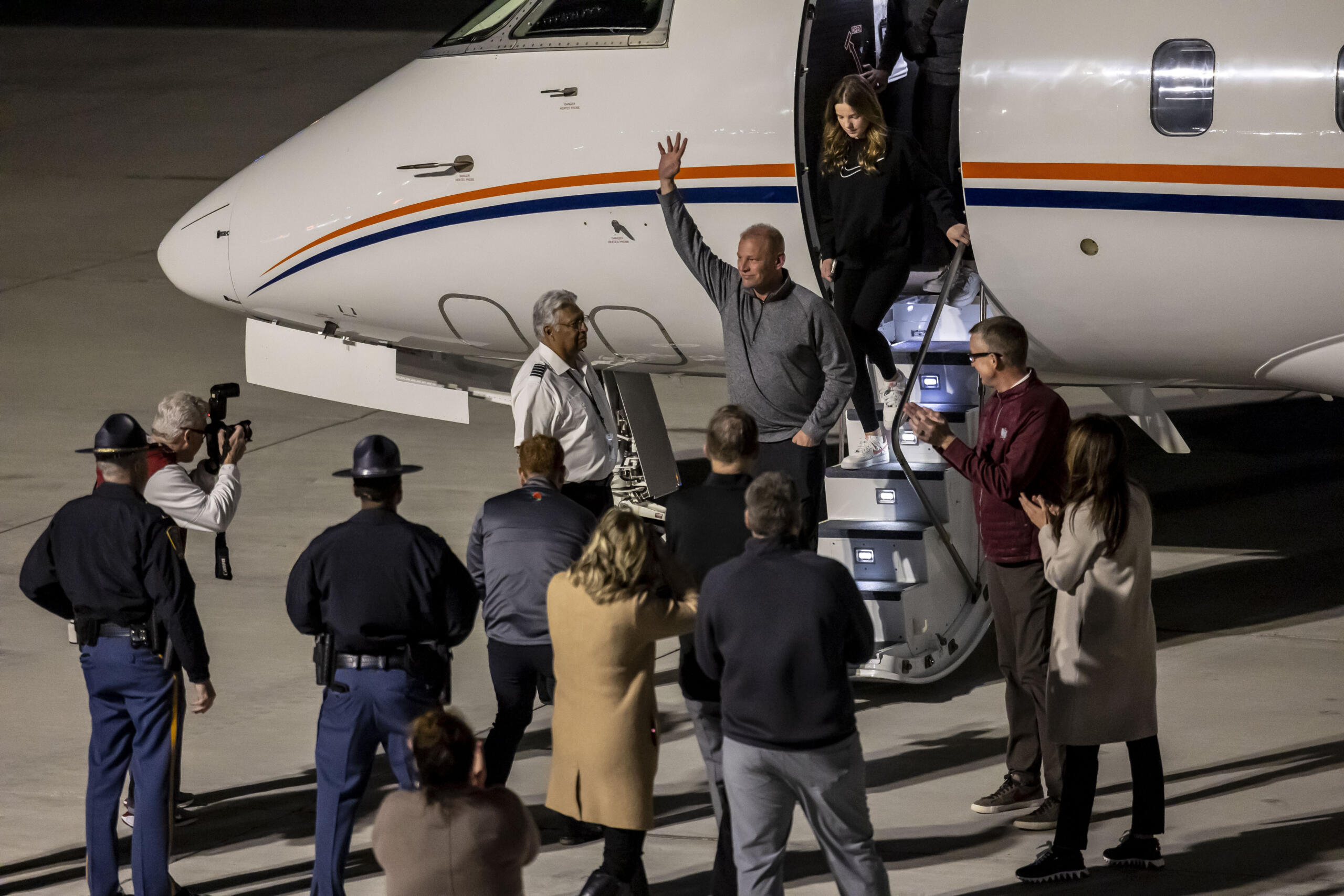 New Alabama football head coach Kalen DeBoer, center, waves to cheering fans as he steps off the plane at Tuscaloosa National Airport two days after former coach Nick Saban announced his retirement Friday, Jan. 12, 2024, in Tuscaloosa, Ala.