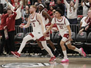 Washington State guards Jabe Mullins (3), Isaiah Watts (12) and teammates celebrate after their win over Arizona in an NCAA college basketball game, Saturday, Jan. 13, 2024, in Pullman, Wash.