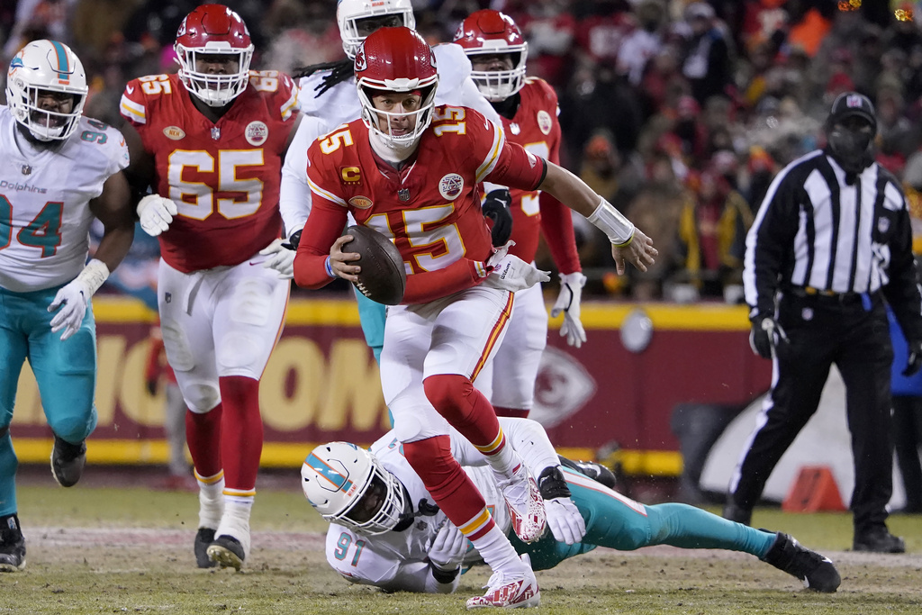 Kansas City Chiefs quarterback Patrick Mahomes (15) runs in front of Miami Dolphins defensive end Emmanuel Ogbah (91) during the first half of an NFL wild-card playoff football game Saturday, Jan. 13, 2024, in Kansas City, Mo.