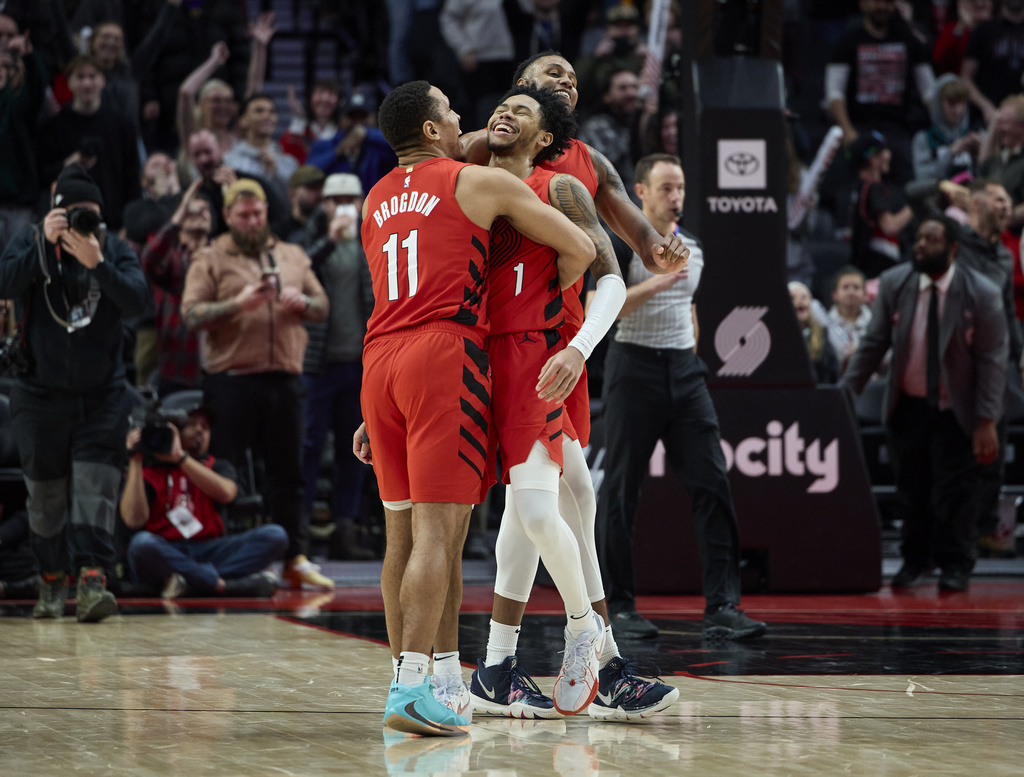 Portland Trail Blazers guard Anfernee Simons, center, celebrates with guard Malcolm Brogdon, left, and forward Jabari Walker after making the go-ahead basket against the Brooklyn Nets in the final second of an NBA basketball game in Portland, Ore., Wednesday, Jan. 17, 2024.