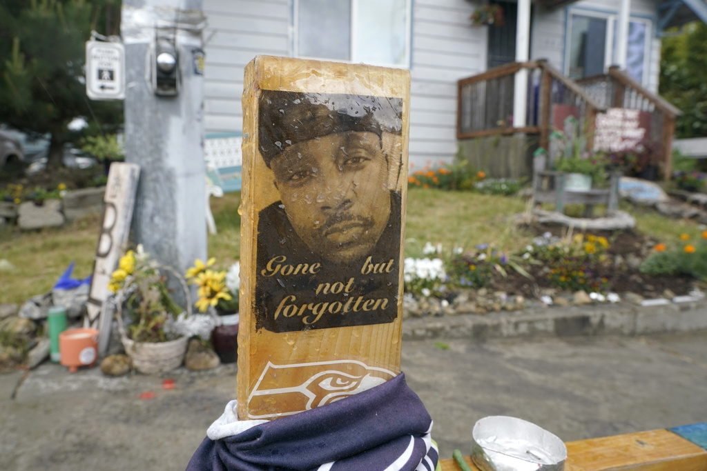 FILE -A sign that reads "Gone but not forgotten" is shown on a cross displayed Thursday, May 27, 2021, at a memorial that has been established at the intersection in Tacoma, Wash., south of Seattle, where Manuel "Manny" Ellis died on March 3, 2020, after he was restrained by police officers. Democratic Sen. Yasmin Trudeau, a Washington state lawmaker wants to prohibit police from hog-tying people, nearly four years after Manuel Ellis died facedown with his hands and feet cuffed together behind him in a case that became a touchstone for racial justice demonstrators in the Pacific Northwest. (AP Photo/Ted S.