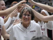Stanford coach Tara VanDerveer smiles as players celebrate her 1,202nd victory as a college coach, against Oregon in an NCAA basketball game Friday, Jan. 19, 2024, in Stanford, Calif. VanDerveer tied former Duke men's basketball coach Mike Krzyzewski for the most wins.