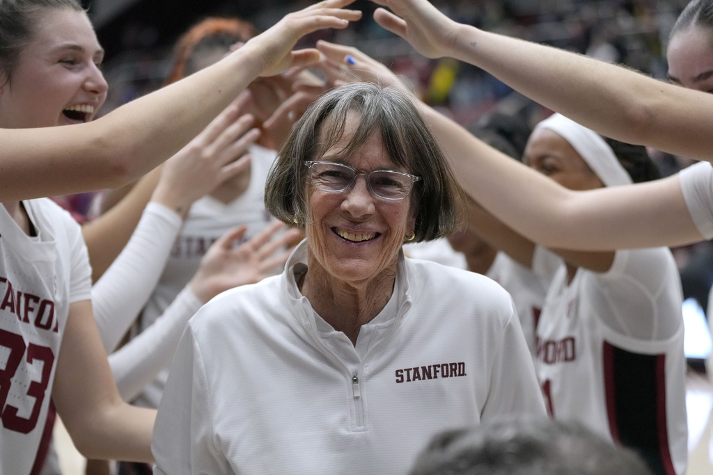 Stanford coach Tara VanDerveer smiles as players celebrate her 1,202nd victory as a college coach, against Oregon in an NCAA basketball game Friday, Jan. 19, 2024, in Stanford, Calif. VanDerveer tied former Duke men's basketball coach Mike Krzyzewski for the most wins.