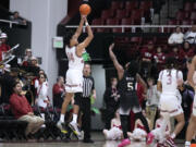 Stanford forward Spencer Jones (14) shoots a 3-point basket over Washington guard Sahvir Wheeler (5) during the first half of an NCAA college basketball game Saturday, Jan. 20, 2024, in Stanford, Calif.